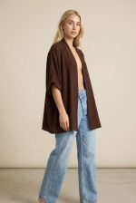 Το μακρύ καφέ crepe kimono είναι το απόλυτο κομμάτι για κομψά και ευέλικτα layering looks. Με χαλαρή γραμμή και αέρινη κίνηση, προσφέρει άνεση και στυλ σε κάθε εμφάνιση. Η μαλακή crepe υφή με non-iron ιδιότητα το καθιστά πρακτικό και ιδανικό για καθημερινή χρήση, ενώ τα φαρδιά 3/4 μανίκια προσθέτουν μία minimal αλλά elegant αισθητική. Μπορεί να φορεθεί τόσο ως kimono πάνω από outfit, όσο και ως μπλούζα για πιο σύγχρονα looks. Ένα versatile κομμάτι που αναβαθμίζει εύκολα κάθε σύνολο.  Styling Tips • Φόρεσέ το πάνω από φόρεμα για elegant layering • Συνδύασέ το με jeans και top για casual chic look • Κλείσε το και φόρεσέ το σαν μπλούζα για minimal outfit • Ιδανικό με σανδάλια ή heels για διαφορετικά styles