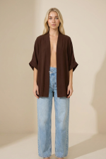 Το μακρύ καφέ crepe kimono είναι το απόλυτο κομμάτι για κομψά και ευέλικτα layering looks. Με χαλαρή γραμμή και αέρινη κίνηση, προσφέρει άνεση και στυλ σε κάθε εμφάνιση. Η μαλακή crepe υφή με non-iron ιδιότητα το καθιστά πρακτικό και ιδανικό για καθημερινή χρήση, ενώ τα φαρδιά 3/4 μανίκια προσθέτουν μία minimal αλλά elegant αισθητική. Μπορεί να φορεθεί τόσο ως kimono πάνω από outfit, όσο και ως μπλούζα για πιο σύγχρονα looks. Ένα versatile κομμάτι που αναβαθμίζει εύκολα κάθε σύνολο.  Styling Tips • Φόρεσέ το πάνω από φόρεμα για elegant layering • Συνδύασέ το με jeans και top για casual chic look • Κλείσε το και φόρεσέ το σαν μπλούζα για minimal outfit • Ιδανικό με σανδάλια ή heels για διαφορετικά styles