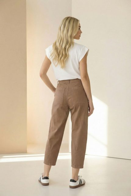 Βαμβακερό Παντελόνι Carrot Fit in brown Το βαμβακερό παντελόνι carrot fit 7/8 είναι η ιδανική επιλογή για σύγχρονες, άνετες αλλά και κομψές καθημερινές εμφανίσεις. Η carrot γραμμή στενεύει ελαφρώς προς τον αστράγαλο, δημιουργώντας κολακευτική σιλουέτα, ενώ το 7/8 μήκος προσθέτει μοντέρνο χαρακτήρα στο look. Η μαλακή cotton σύνθεση με ελαστικότητα εξασφαλίζει άνεση και ευελιξία στην κίνηση, ιδανική για all-day χρήση. Διαθέτει πρακτικές τσέπες και εφαρμόζει όμορφα στη μέση, προσφέροντας σταθερότητα και άνετη εφαρμογή. Κατάλληλο για casual, office και city outfits, συνδυάζεται εύκολα με πουκάμισα, t-shirts ή πλεκτά. Styling Tip Συνδύασέ το με cropped cardigan ή basic t-shirt για minimal καθημερινό look. Με πουκάμισο και ankle boots δημιουργεί smart casual σύνολο, ενώ με sneakers αποκτά πιο relaxed χαρακτήρα.