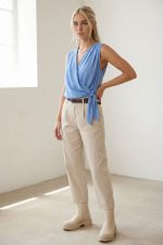 Κρουαζέ Crepe Αμάνικο Top in Baby Blue Κωδ.: 242 Το κρουαζέ crepe αμάνικο top σε απαλή baby blue απόχρωση είναι ένα κομψό και διαχρονικό κομμάτι που αναδεικνύει τη θηλυκή σιλουέτα. Ο κρουαζέ σχεδιασμός αγκαλιάζει το σώμα με φυσική ροή, ενώ το δέσιμο στο πλάι προσθέτει κομψή λεπτομέρεια και επιτρέπει ελαφριά προσαρμογή στην εφαρμογή. Το crepe ύφασμα χαρίζει ανάλαφρη αίσθηση και όμορφη κίνηση, χωρίς να κολλάει στο σώμα. Είναι non-iron, ιδανικό για καθημερινή χρήση αλλά και για πιο προσεγμένες εμφανίσεις. Φοριέται εύκολα από το πρωί έως το βράδυ, συνδυάζοντας άνεση και chic αισθητική. Styling Tip Συνδύασέ το με carrot ή tailored παντελόνι και ζώνη για κομψό office look. Με wide leg παντελόνι δημιουργεί πιο αέρινη σιλουέτα, ενώ με denim και sneakers αποκτά πιο relaxed χαρακτήρα.