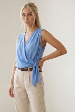 Κρουαζέ Crepe Αμάνικο Top in Baby Blue Κωδ.: 242 Το κρουαζέ crepe αμάνικο top σε απαλή baby blue απόχρωση είναι ένα κομψό και διαχρονικό κομμάτι που αναδεικνύει τη θηλυκή σιλουέτα. Ο κρουαζέ σχεδιασμός αγκαλιάζει το σώμα με φυσική ροή, ενώ το δέσιμο στο πλάι προσθέτει κομψή λεπτομέρεια και επιτρέπει ελαφριά προσαρμογή στην εφαρμογή. Το crepe ύφασμα χαρίζει ανάλαφρη αίσθηση και όμορφη κίνηση, χωρίς να κολλάει στο σώμα. Είναι non-iron, ιδανικό για καθημερινή χρήση αλλά και για πιο προσεγμένες εμφανίσεις. Φοριέται εύκολα από το πρωί έως το βράδυ, συνδυάζοντας άνεση και chic αισθητική. Styling Tip Συνδύασέ το με carrot ή tailored παντελόνι και ζώνη για κομψό office look. Με wide leg παντελόνι δημιουργεί πιο αέρινη σιλουέτα, ενώ με denim και sneakers αποκτά πιο relaxed χαρακτήρα.
