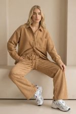 Το Oversized Σετ Κοτλέ in camel είναι η ιδανική επιλογή για να αναδείξετε το στυλ σας με άνεση! Το σετ συνδυάζει την πρακτικότητα με την κομψότητα: η φαρδιά γραμμή της πουκαμίσας και της παντελόνας εξασφαλίζει άνετη εφαρμογή, ενώ το απαλό κοτλέ ύφασμα προσφέρει αίσθηση πολυτέλειας. Η παντελόνα με το ελαστικό λάστιχο και κορδόνι αγκαλιάζει το σώμα, προσαρμόζοντας την εφαρμογή στις ανάγκες σας. Η πουκαμίσα με την oversized γραμμή της συμπληρώνει την εμφάνιση, χαρίζοντας μία μοντέρνα και χαλαρή αισθητική. Στυλιστική Συμβουλή: Συνδυάστε το με sneakers για ένα casual look ή με ankle boots για πιο κομψές εμφανίσεις. Προσθέστε ένα μακρύ παλτό ή μία δερμάτινη τσάντα για ένα ολοκληρωμένο, μοντέρνο outfit.
