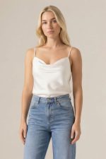 Draped Satin Cami Top in White Κωδικός: 17096 Το Draped Satin Cami Top in white είναι ένα διαχρονικό essential που αποπνέει καθαρότητα και σύγχρονη κομψότητα. Το σατινέ ύφασμα είναι δροσερό, ανάλαφρο και non-iron, προσφέροντας άνεση και άψογη εικόνα χωρίς προσπάθεια. Η κανονική προς χαλαρή γραμμή και το One Size που καλύπτει έως L  εξασφαλίζουν εύκολη εφαρμογή, ενώ η διπλής όψης σχεδίαση επιτρέπει να φορεθεί και από την πίσω πλευρά για διαφορετικά styling moods. Ένα κομμάτι που λειτουργεί ιδανικά ως βάση για minimal, capsule εμφανίσεις. Styling Tip Δημιούργησε ένα ton-sur-ton σύνολο συνδυάζοντάς το με λευκό ή off-white tailored παντελόνι για καθαρό, sophisticated αποτέλεσμα. Ολοκλήρωσε με minimal σανδάλια ή loafers και διακριτικά κοσμήματα για effortless chic εμφανίσεις από το πρωί έως το βράδυ.