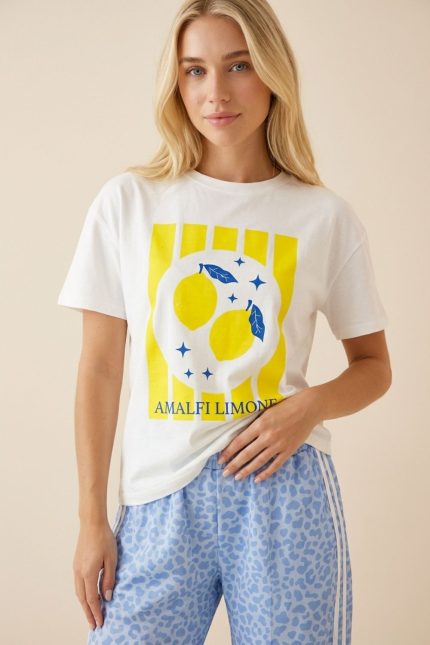 Βαμβακερό Κοντομάνικο T-Shirt Amalfi Limone Περιγραφή Προϊόντος Το βαμβακερό κοντομάνικο T-Shirt “Amalfi Limone” αποπνέει καλοκαιρινή φρεσκάδα και ιταλικό αέρα. Η εντυπωσιακή lemon στάμπα σε φωτεινές κίτρινες αποχρώσεις χαρίζει playful και κομψό χαρακτήρα, ιδανικό για ανοιξιάτικα και καλοκαιρινά outfits. Η γραμμή του είναι άνετη και χαλαρή, καλύπτει έως Large και εφαρμόζει όμορφα χωρίς να πιέζει. Το μαλακό βαμβακερό ύφασμα με ελαστικότητα προσφέρει άνεση και φυσική εφαρμογή καθ’ όλη τη διάρκεια της ημέρας. Styling Tip Συνδύασέ το με τη γαλάζια ψηλόμεση παντελόνα wide leg για ένα φωτεινό, ισορροπημένο και κομψό καλοκαιρινό look. Εναλλακτικά, φόρεσέ το με denim shorts για πιο casual αποτέλεσμα ή με λευκό παντελόνι για καθαρό, resort-inspired outfit.