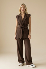  Elegant Tailored Look | WhiteTie.gr Το σετ με γιλέκο και παντελόνι σε καφέ απόχρωση αποτελεί την απόλυτη επιλογή για κομψές και σύγχρονες εμφανίσεις. Με minimal tailored αισθητική, συνδυάζει δυναμικό χαρακτήρα και θηλυκή κομψότητα. Το γιλέκο διαθέτει ζώνη στη μέση που τονίζει τη σιλουέτα, ενώ το structured σχέδιο του προσφέρει ένα elegant αποτέλεσμα. Το παντελόνι με ίσια γραμμή ολοκληρώνει το σύνολο, δημιουργώντας ένα ισορροπημένο και sophisticated look. Ιδανικό για office εμφανίσεις, events ή chic καθημερινά outfits.  Styling Tips • Φόρεσέ το με heels για elegant & δυναμικό look • Συνδύασέ το με sneakers για πιο relaxed style • Πρόσθεσε minimal κοσμήματα για chic αποτέλεσμα • Μπορείς να φορέσεις το γιλέκο και μόνο του για πιο statement outfit