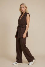  Elegant Tailored Look | WhiteTie.gr Το σετ με γιλέκο και παντελόνι σε καφέ απόχρωση αποτελεί την απόλυτη επιλογή για κομψές και σύγχρονες εμφανίσεις. Με minimal tailored αισθητική, συνδυάζει δυναμικό χαρακτήρα και θηλυκή κομψότητα. Το γιλέκο διαθέτει ζώνη στη μέση που τονίζει τη σιλουέτα, ενώ το structured σχέδιο του προσφέρει ένα elegant αποτέλεσμα. Το παντελόνι με ίσια γραμμή ολοκληρώνει το σύνολο, δημιουργώντας ένα ισορροπημένο και sophisticated look. Ιδανικό για office εμφανίσεις, events ή chic καθημερινά outfits.  Styling Tips • Φόρεσέ το με heels για elegant & δυναμικό look • Συνδύασέ το με sneakers για πιο relaxed style • Πρόσθεσε minimal κοσμήματα για chic αποτέλεσμα • Μπορείς να φορέσεις το γιλέκο και μόνο του για πιο statement outfit