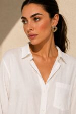 Viscose Oversized Shirt in  white Κωδικός: 200226 Χαρακτηριστικά Προϊόντος • Εφαρμογή: Oversized, χαλαρή γραμμή • One Size – καλύπτει έως X-Large • Περιφέρεια στήθους: έως 120 cm • Μαλακό, ελαφρύ και breathable ύφασμα viscose • Κατάλληλο για ευαίσθητα & αλλεργικά δέρματα • Roll-up μανίκι • Φοριέται ως πουκάμισο ή ελαφρύ jacket • Ιδανικό για layering Διαστάσεις (flat ) • Στήθος: έως 120 cm • Μήκος μπροστά: περίπου 72 cm • Μήκος πίσω: περίπου 76 cm • Μανίκι: περίπου 60 cm Φροντίδα • Πλύσιμο στο πλυντήριο έως 30°C • Χωρίς στύψιμο • Σιδέρωμα σε χαμηλή θερμοκρασία
