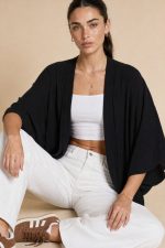 Ζακέτα kimono in black Η  ζακέτα kimono in black είναι ένα απόλυτα versatile κομμάτι που προσαρμόζεται σε κάθε στυλ. Με μακριά, χαλαρή γραμμή και minimal αισθητική, προσφέρει άνεση και κομψότητα σε κάθε εμφάνιση. Το ελαφρύ crepe ύφασμα χαρίζει ανάλαφρη αίσθηση και φυσική κίνηση, ενώ τα φαρδιά 3/4 μανίκια δημιουργούν ένα elegant και σύγχρονο αποτέλεσμα. Το ιδιαίτερο χαρακτηριστικό του είναι ότι φοριέται και ανάποδα σαν μπλούζα, δημιουργώντας ένα εντυπωσιακό άνοιγμα στην πλάτη, δίνοντας extra styling επιλογές από ένα μόνο κομμάτι. Ιδανικό για layering αλλά και για statement εμφανίσεις. Styling Tips • Φόρεσέ το ανοιχτό πάνω από outfit για effortless layering • Συνδύασέ το με jeans για casual chic look • Φόρεσέ το ανάποδα σαν blouse με άνοιγμα στην πλάτη για πιο ιδιαίτερο στυλ • Ιδανικό με heels ή mules για elegant εμφανίσεις