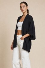 Ζακέτα kimono in black Η  ζακέτα kimono in black είναι ένα απόλυτα versatile κομμάτι που προσαρμόζεται σε κάθε στυλ. Με μακριά, χαλαρή γραμμή και minimal αισθητική, προσφέρει άνεση και κομψότητα σε κάθε εμφάνιση. Το ελαφρύ crepe ύφασμα χαρίζει ανάλαφρη αίσθηση και φυσική κίνηση, ενώ τα φαρδιά 3/4 μανίκια δημιουργούν ένα elegant και σύγχρονο αποτέλεσμα. Το ιδιαίτερο χαρακτηριστικό του είναι ότι φοριέται και ανάποδα σαν μπλούζα, δημιουργώντας ένα εντυπωσιακό άνοιγμα στην πλάτη, δίνοντας extra styling επιλογές από ένα μόνο κομμάτι. Ιδανικό για layering αλλά και για statement εμφανίσεις. Styling Tips • Φόρεσέ το ανοιχτό πάνω από outfit για effortless layering • Συνδύασέ το με jeans για casual chic look • Φόρεσέ το ανάποδα σαν blouse με άνοιγμα στην πλάτη για πιο ιδιαίτερο στυλ • Ιδανικό με heels ή mules για elegant εμφανίσεις