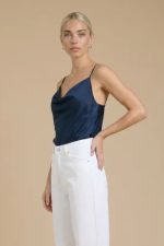 Το satin top που κάνει τη διαφορά χωρίς υπερβολές. Το Draped Satin Cami ξεχωρίζει με τη διακριτική draped λεπτομέρεια, προσθέτοντας κίνηση και κομψότητα σε κάθε look. Η σατινέ υφή του είναι απαλή, δροσερή και breathable, ενώ η χαλαρή εφαρμογή αγκαλιάζει το σώμα με effortless τρόπο. Το πιο δυνατό του σημείο; Διπλής όψης design – φοριέται και από την πίσω πλευρά, δίνοντάς σου 2 διαφορετικά looks με ένα κομμάτι. Τα ρυθμιζόμενα ραντάκια εξασφαλίζουν ιδανική εφαρμογή, προσαρμοσμένη σε κάθε σωματότυπο. Styling Mood • Με wide leg παντελόνι → elegant & polished outfit • Με jeans → easy βραδινό look • Με σακάκι → minimal chic layering • Ανάποδα φορεμένο → πιο clean, less draped αισθητική