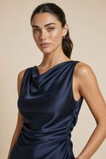 Satin Draped Back Dress Ένα φόρεμα που τραβάει όλα τα βλέμματα… όταν γυρίσεις πλάτη. Το Satin Draped Back Dress συνδυάζει minimal πολυτέλεια με έντονη θηλυκότητα, χάρη στο εντυπωσιακό ανοιχτό κρουαζέ πίσω μέρος και το ντραπέ design που αγκαλιάζει το σώμα με φυσική ροή. Η σατινέ υφή του είναι απαλή, δροσερή και κομψή, δημιουργώντας ένα effortless elegant αποτέλεσμα ιδανικό για καλοκαιρινές εμφανίσεις, events ή βραδινές εξόδους. Ένα κομμάτι που δεν χρειάζεται πολλά – απλά το φοράς και ξεχωρίζεις.  Styling Mood • Με minimal πέδιλα → clean elegant look • Με statement σκουλαρίκια → πιο glamorous αποτέλεσμα • Με flat σανδάλια → island chic vibe • Με loose μαλλιά & glow skin → effortless luxury