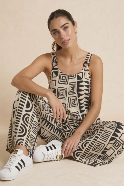 Η Nefeli Ολόσωμη Φόρμα είναι η definition του effortless summer style. Με αέρινη oversized γραμμή και wide leg εφαρμογή, προσφέρει απόλυτη άνεση και κομψότητα σε κάθε κίνηση. Το minimal geometric print σε neutral αποχρώσεις δημιουργεί elevated resort αισθητική, ενώ οι ιδιαίτερες λεπτομέρειες στους ώμους με κρίκους δίνουν modern χαρακτήρα στο look. Το ανάλαφρο breathable ύφασμά της χαρίζει δροσερή αίσθηση ακόμα και τις πιο ζεστές ημέρες, ενώ η απαλή υφή την κάνει ιδανική για ευαίσθητα ή αλλεργικά δέρματα.