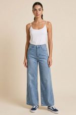 Wide Leg Ψηλόμεσο Τζιν Παντελόνι με Strass Τσέπη Το Wide Leg Ψηλόμεσο Τζιν Παντελόνι με Strass Τσέπη είναι το denim piece που συνδυάζει effortless άνεση με elevated λεπτομέρειες. Με ψηλόμεση εφαρμογή, wide leg γραμμή και μαλακό ελαστικό βαμβακερό denim, αγκαλιάζει το σώμα χωρίς να πιέζει και προσφέρει άνεση όλη μέρα. Η minimal strass λεπτομέρεια στην πίσω τσέπη χαρίζει διακριτική λάμψη και κάνει το jeans να ξεχωρίζει. Η wide leg γραμμή του δημιουργεί elegant silhouette και ταιριάζει ιδανικά από casual city looks μέχρι πιο elevated καθημερινά outfits.  Styling Tip Συνδύασέ το με rib top ή σατινέ cami top από τη συλλογή μας και sneakers για effortless καθημερινό look ή με πέδιλα για elevated casual εμφανίσεις.