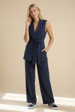 Navy Σετ Γιλέκο και Παντελόνι Minimal, κομψό και effortlessly chic, το Navy Σετ Γιλέκο και Παντελόνι είναι το απόλυτο co-ord set για all day εμφανίσεις με elevated αισθητική. Το αμάνικο tailored γιλέκο με ζώνη στη μέση δημιουργεί κομψή σιλουέτα και συνδυάζεται τέλεια με το άνετο ίσιο παντελόνι, προσφέροντας sophisticated look χωρίς να χάνει σε άνεση. Το ύφασμά του έχει μαλακή αίσθηση, στρώνει υπέροχα στο σώμα και είναι ιδανικό τόσο για office looks όσο και για πιο stylish καθημερινές εμφανίσεις.  Styling Tip Συνδύασέ το με λευκό rib top ή σατινέ lingerie top από τη συλλογή μας για elegant minimal looks από το πρωί μέχρι το βράδυ.
