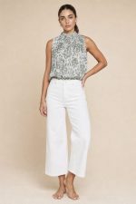 Animal Print Neckhalter Top in Sage Το Animal Print Neckhalter Top in Sage είναι το απόλυτο statement κομμάτι για chic καλοκαιρινές εμφανίσεις με elegant boho αισθητική. Το ιδιαίτερο animal print σε sage αποχρώσεις συνδυάζεται με διακριτική glitter κλωστή μέσα στο pattern, χαρίζοντας subtle λάμψη και elevated αποτέλεσμα. Η balloon fit γραμμή αγκαλιάζει άνετα το σώμα, ενώ το neckhalter δέσιμο με κουμπάκια στον λαιμό δημιουργεί θηλυκή και sophisticated σιλουέτα. Το λάστιχο στο τελείωμα προσφέρει άνεση και όμορφο στρώσιμο στο σώμα. Το ύφασμα με viscose φόδρα εσωτερικά και crepe εξωτερικά είναι εξαιρετικά μαλακό, breathable και ιδανικό ακόμα και για ευαίσθητο δέρμα. Styling Tip Συνδύασέ το με λινή παντελόνα ή wide leg jeans από τη συλλογή μας για effortless chic looks ή φόρεσέ το με satin φούστα και χρυσά αξεσουάρ για πιο elevated βραδινές εμφανίσεις.
