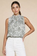 Animal Print Neckhalter Top in Sage Το Animal Print Neckhalter Top in Sage είναι το απόλυτο statement κομμάτι για chic καλοκαιρινές εμφανίσεις με elegant boho αισθητική. Το ιδιαίτερο animal print σε sage αποχρώσεις συνδυάζεται με διακριτική glitter κλωστή μέσα στο pattern, χαρίζοντας subtle λάμψη και elevated αποτέλεσμα. Η balloon fit γραμμή αγκαλιάζει άνετα το σώμα, ενώ το neckhalter δέσιμο με κουμπάκια στον λαιμό δημιουργεί θηλυκή και sophisticated σιλουέτα. Το λάστιχο στο τελείωμα προσφέρει άνεση και όμορφο στρώσιμο στο σώμα. Το ύφασμα με viscose φόδρα εσωτερικά και crepe εξωτερικά είναι εξαιρετικά μαλακό, breathable και ιδανικό ακόμα και για ευαίσθητο δέρμα. Styling Tip Συνδύασέ το με λινή παντελόνα ή wide leg jeans από τη συλλογή μας για effortless chic looks ή φόρεσέ το με satin φούστα και χρυσά αξεσουάρ για πιο elevated βραδινές εμφανίσεις.