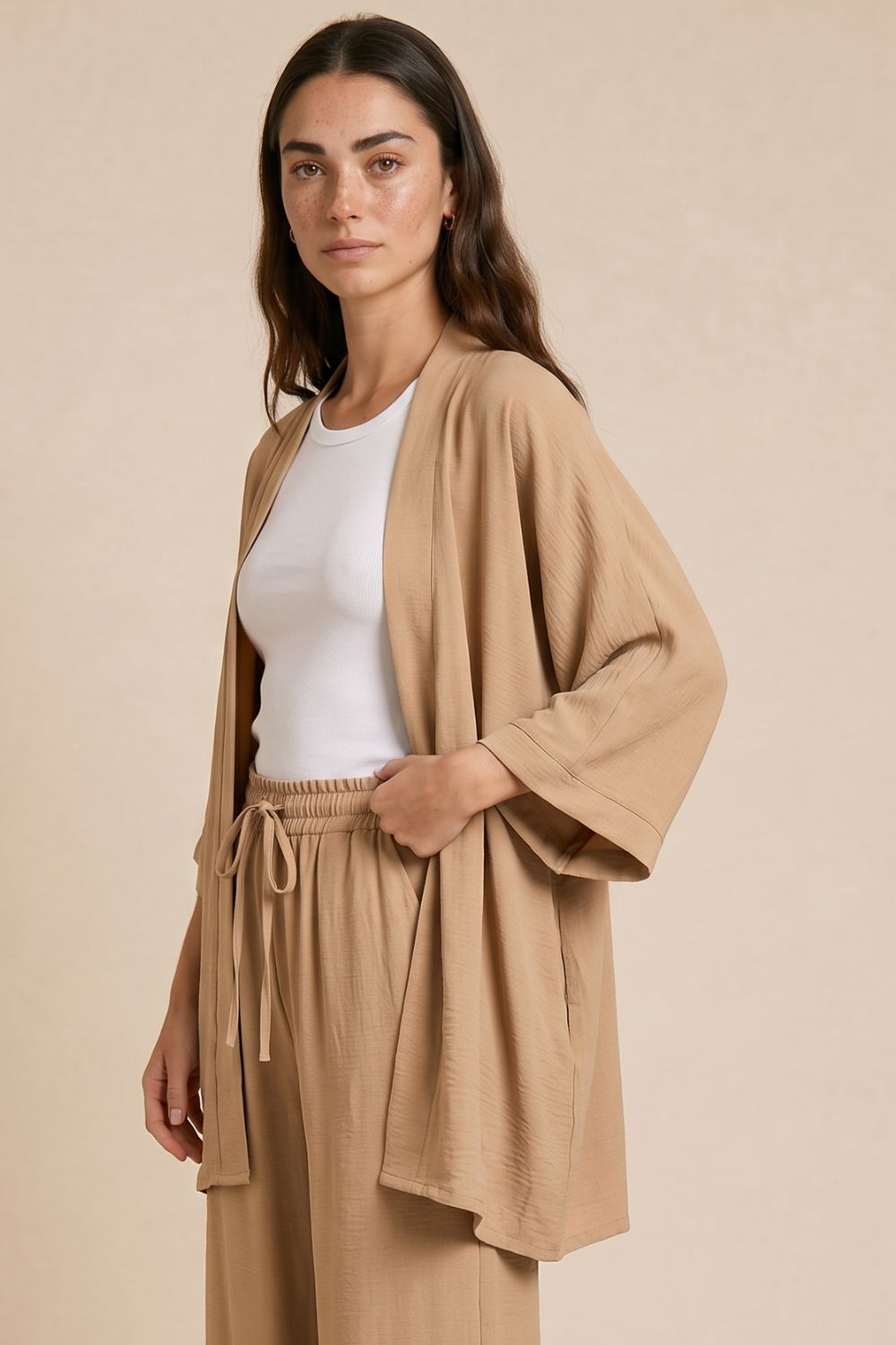 Σετ Κιμονό Παντελόνα Crepe in Camel  Χαρακτηριστικά Προϊόντος Kimono • One Size Fit (καλύπτει έως X-Large) • Φαρδιά 3/4 μανίκια σε τετράγωνη γραμμή • Loose & αέρινη εφαρμογή • Ανάλαφρη κίνηση που ρέει όμορφα στο σώμα • Ύφασμα: Crepe • Υφή: Δροσερή & breathable • Στήθος: έως 115 cm • Εφαρμογή: καλύπτει έως XL Παντελόνα • Ύφασμα crêpe, ανάλαφρο & άνετο • Wide leg γραμμή • Λάστιχο στη μέση • Άνετη εφαρμογή χωρίς να πιέζει • Elegant flow σε κάθε κίνηση • Μέση: έως 90 cm • Περιφέρεια: έως 115 cm • Μήκος: 99 cm  Φροντίδα • Πλύσιμο έως 30°C • Χωρίς στύψιμο • Φυσικό στέγνωμα Non Iron