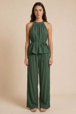 Crinkle Viscose Set  Ανάλαφρο σετ σε γκοφρέ viscose ύφασμα που αποτελείται από halter neck top και wide leg παντελόνα σε relaxed γραμμή. Το ύφασμα είναι εξαιρετικά δροσερό, μαλακό και breathable, ιδανικό για τις ζεστές καλοκαιρινές ημέρες αλλά και για ταξίδια χάρη στην άνετη εφαρμογή και τη φυσική του κίνηση. Το neckholder τοπ διαθέτει κορδονάκι στη μέση για προσαρμοζόμενη εφαρμογή που αγκαλιάζει όμορφα το σώμα χωρίς να πιέζει, ενώ η παντελόνα έχει λάστιχο στο πίσω μέρος και πλαϊνές τσέπες για extra άνεση και πρακτικότητα. Ένα minimal chic co-ord set που μπορεί να φορεθεί από το πρωί έως το βράδυ με effortless elegant αισθητική.  Styling Tip Συνδύασέ το με flat sandals, chunky bangles και woven bag για elevated resort εμφανίσεις. Το olive green είναι από τις πιο elegant και timeless αποχρώσεις του καλοκαιριού και ταιριάζει τέλεια με χρυσά accessories και natural makeup looks.