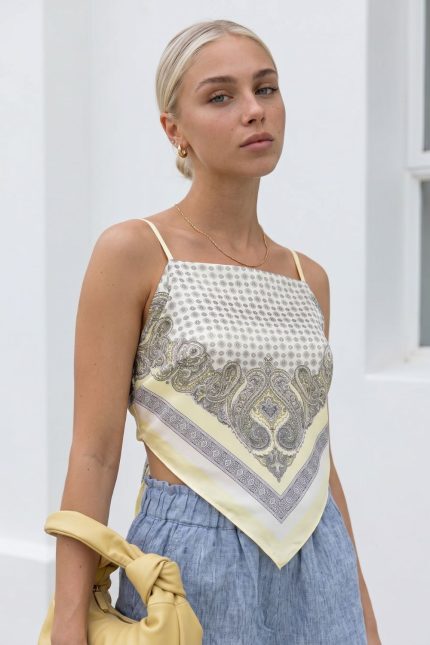 Satin Bandana Top in Yellow  Χαρακτηριστικά Προϊόντος • Satin bandana top με λαχούρι σχέδιο • Ρυθμιζόμενα ραντάκια με αυξομείωση • Δένει στην πλάτη για προσαρμοζόμενη εφαρμογή • Ανοιχτή πλάτη με εντυπωσιακή λεπτομέρεια δεσίματος • Δροσερή και απαλή σατινέ υφή • Ανάλαφρη αίσθηση στο σώμα • Ιδανικό για καλοκαιρινές και resort εμφανίσεις • One Size (καλύπτει έως Medium Plus) Διαστάσεις Μέγεθος Στήθος Μέση One Size έως 100 cm έως 92 cm Φροντίδα • Πλύσιμο έως 30°C • Δεν στύβεται • Σιδέρωμα σε χαμηλή θερμοκρασία με ατμό • Αποφεύγεται το στεγνωτήριο