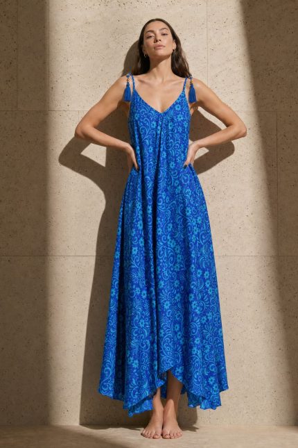 Julie Dress in blue and mint  Χαρακτηριστικά Προϊόντος • Υλικό: 100% Art Silk • Υφή: Ανάλαφρη, δροσερή & σατινέ • Γραμμή: Maxi με αέρινη εφαρμογή • Κόψιμο: Ασύμμετρο που κολακεύει τη σιλουέτα Σχέδιο: Εντυπωσιακό μπλε εμπριμέ print ασύμμετρο σχέδιο   • Λαιμόκοψη: V cut μπροστά & πίσω • Ραντάκια: Κορδονάκια που δένουν και προσαρμόζονται • Τελείωμα: Ασύμμετρο • Ιδιότητα: Non Iron • Μέγεθος: One Size (καλύπτει έως Large Plus)  Διαστάσεις • Στήθος: έως 100–105 cm • Μέση: έως 100 cm • Περιφέρεια: έως 145 cm  Οδηγίες Φροντίδας • Πλύσιμο στο χέρι ή στους 30°C • Χωρίς στύψιμο • Φυσικό στέγνωμα • Δεν απαιτεί σιδέρωμα (non iron)