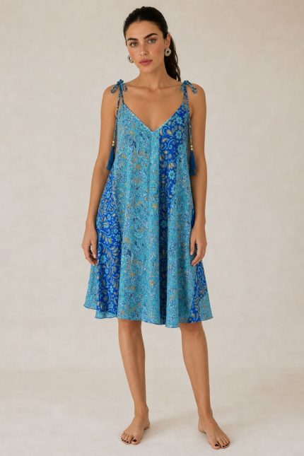 Italy Mini Art Silk Dress Χαρακτηριστικά Προϊόντος • Mini φόρεμα με ιδιαίτερο  print σε αποχρώσεις του γαλάζιου και του μπλε και του χρυσού • V λαιμόκοψη μπροστά και πίσω • Ρυθμιζόμενες τιράντες που δένουν στους ώμους με διακοσμητικές φούντες • Άνετη Α γραμμή που κολακεύει τη σιλουέτα ασύμμετρο σχέδιο  • Ανάλαφρη εφαρμογή με όμορφη κίνηση • One Size – καλύπτει έως X-Large • Ύφασμα Art Silk • Πολύ δροσερό, ανάλαφρο και εξαιρετικά απαλό στην αφή • Δεν διαφανίζει Διαστάσεις Μέγεθος Στήθος Περιφέρεια Μήκος One Size έως 118 cm έως 140 cm 90 cm* *Το μήκος προσαρμόζεται εύκολα χάρη στις τιράντες που δένουν στους ώμους. Οδηγίες Φροντίδας • Πλύσιμο στο κρύο νερό • Χωρίς στύψιμο • Δεν χρειάζεται σιδέρωμα