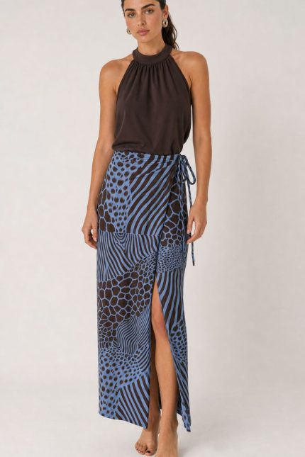 Penelope Viscose Wrap Midi Skirt Κωδικός: 3034 Χαρακτηριστικά Προϊόντος • Πολυμορφική κρουαζέ midi φούστα • Εσωτερικό φύλλο που ασφαλίζει με κορδονάκι • Εξωτερικό φύλλο που τυλίγει το σώμα και δένει στη μέση • Ρυθμιζόμενη εφαρμογή που προσαρμόζεται εύκολα στη σιλουέτα • Άνετη γραμμή με φυσική κίνηση • Midi μήκος • Ασύμμετρο τελείωμα • One Size – καλύπτει έως X-Large • Viscose blend σύνθεση καφέ-μπλέ  αποχρωση • Ανάλαφρη, δροσερή και breathable αίσθηση • Πολύ μαλακή υφή με όμορφη εφαρμογή Διαστάσεις (One Size) • Μέση: έως 105 cm (ρυθμιζόμενη με δέσιμο) • Περιφέρεια: έως 120 cm • Μήκος: Midi Asymmetrical Οδηγίες Φροντίδας • Πλύσιμο στους 30°C • Χωρίς στύψιμο • Σιδέρωμα σε χαμηλή θερμοκρασία