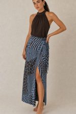 Penelope Viscose Wrap Midi Skirt Κωδικός: 3034 Χαρακτηριστικά Προϊόντος • Πολυμορφική κρουαζέ midi φούστα • Εσωτερικό φύλλο που ασφαλίζει με κορδονάκι • Εξωτερικό φύλλο που τυλίγει το σώμα και δένει στη μέση • Ρυθμιζόμενη εφαρμογή που προσαρμόζεται εύκολα στη σιλουέτα • Άνετη γραμμή με φυσική κίνηση • Midi μήκος • Ασύμμετρο τελείωμα • One Size – καλύπτει έως X-Large • Viscose blend σύνθεση καφέ-μπλέ  αποχρωση • Ανάλαφρη, δροσερή και breathable αίσθηση • Πολύ μαλακή υφή με όμορφη εφαρμογή Διαστάσεις (One Size) • Μέση: έως 105 cm (ρυθμιζόμενη με δέσιμο) • Περιφέρεια: έως 120 cm • Μήκος: Midi Asymmetrical Οδηγίες Φροντίδας • Πλύσιμο στους 30°C • Χωρίς στύψιμο • Σιδέρωμα σε χαμηλή θερμοκρασία