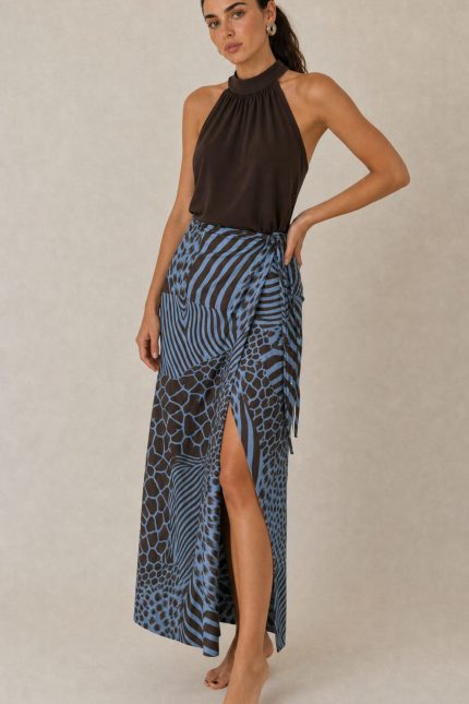 Penelope Viscose Wrap Midi Skirt Κωδικός: 3034 Χαρακτηριστικά Προϊόντος • Πολυμορφική κρουαζέ midi φούστα • Εσωτερικό φύλλο που ασφαλίζει με κορδονάκι • Εξωτερικό φύλλο που τυλίγει το σώμα και δένει στη μέση • Ρυθμιζόμενη εφαρμογή που προσαρμόζεται εύκολα στη σιλουέτα • Άνετη γραμμή με φυσική κίνηση • Midi μήκος • Ασύμμετρο τελείωμα • One Size – καλύπτει έως X-Large • Viscose blend σύνθεση καφέ-μπλέ  αποχρωση • Ανάλαφρη, δροσερή και breathable αίσθηση • Πολύ μαλακή υφή με όμορφη εφαρμογή Διαστάσεις (One Size) • Μέση: έως 105 cm (ρυθμιζόμενη με δέσιμο) • Περιφέρεια: έως 120 cm • Μήκος: Midi Asymmetrical Οδηγίες Φροντίδας • Πλύσιμο στους 30°C • Χωρίς στύψιμο • Σιδέρωμα σε χαμηλή θερμοκρασία
