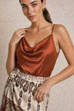 Lefkada Viscose Wrap Midi Skirt Κωδικός: 3033 Χαρακτηριστικά Προϊόντος • Πολυμορφική κρουαζέ midi φούστα • Εσωτερικό φύλλο που ασφαλίζει με κορδονάκι • Εξωτερικό φύλλο που τυλίγει το σώμα και δένει στη μέση • Ρυθμιζόμενη εφαρμογή που προσαρμόζεται εύκολα στη σιλουέτα • Άνετη γραμμή με φυσική κίνηση • Midi μήκος • Ασύμμετρο τελείωμα • One Size – καλύπτει έως X-Large • Viscose blend σύνθεση καφέ  αποχρωση • Ανάλαφρη, δροσερή και breathable αίσθηση • Πολύ μαλακή υφή με όμορφη εφαρμογή Διαστάσεις (One Size) • Μέση: έως 105 cm (ρυθμιζόμενη με δέσιμο) • Περιφέρεια: έως 120 cm • Μήκος: Midi Asymmetrical Οδηγίες Φροντίδας • Πλύσιμο στους 30°C • Χωρίς στύψιμο • Σιδέρωμα σε χαμηλή θερμοκρασία