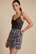 Bella Viscose Wrap Mini Skirt in indigo Κωδικός: 7891 Χαρακτηριστικά Προϊόντος • Mini κρουαζέ φούστα με ρυθμιζόμενο δέσιμο στη μέση • Διπλή εφαρμογή με εσωτερικό και εξωτερικό δέσιμο • Εσωτερικό φύλλο που ασφαλίζει με κορδονάκι • Εξωτερικό φύλλο που αγκαλιάζει το σώμα και δένει στη μέση • Προσαρμόζεται εύκολα στη σιλουέτα • Άνετη και θηλυκή γραμμή • One Size – καλύπτει έως Large • Ύφασμα από viscose blend σύνθεση • Ανάλαφρη, δροσερή και breathable αίσθηση • Μαλακή υφή με όμορφη φυσική κίνηση • Ιδανική για καθημερινές εμφανίσεις και καλοκαιρινά looks Διαστάσεις (One Size) • Μέση: έως 100 cm (ρυθμιζόμενη με δέσιμο) • Περιφέρεια: έως 110 cm • Μήκος: Mini Οδηγίες Φροντίδας • Πλύσιμο στους 30°C • Χωρίς στύψιμο • Σιδέρωμα σε χαμηλή θερμοκρασία
