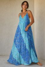 Bestie Art Silk Maxi Dress in blue gold Χαρακτηριστικά Προϊόντος • Maxi φόρεμα σε αέρινη και ιδιαίτερα θηλυκή γραμμή • Εντυπωσιακό εμπριμέ print σε αποχρώσεις του blue-gold-turquoise • 100% Art Silk ύφασμα • Ανάλαφρη, δροσερή και μεταξένια υφή • V λαιμόκοψη μπροστά και πίσω • Λεπτά ραντάκια που αναδεικνύουν τους ώμους • Ασύμμετρο τελείωμα με πλούσια κίνηση • Oversized εφαρμογή που αγκαλιάζει όμορφα τη σιλουέτα • Δεν διαφανίζει • Non Iron – δεν χρειάζεται σιδέρωμα • One Size – καλύπτει έως Large Plus Διαστάσεις Μέγεθος Στήθος Μέση Περιφέρεια One Size έως 120 cm έως 115 cm έως 145 cm Σύνθεση • 100% Art Silk Φροντίδα • Πλύσιμο στο χέρι ή σε κρύο νερό • Χωρίς στύψιμο • Φυσικό στέγνωμα • Δεν απαιτεί σιδέρωμα (Non Iron)