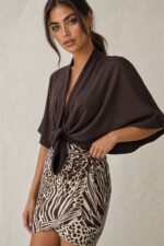 Melia Φούστα Mini Κρουαζέ Brown Χαρακτηριστικά Προϊόντος • Mini κρουαζέ / wrap σχεδιασμός • Animal print σε καφέ & εκρού αποχρώσεις • Δένει στη μέση για ρυθμιζόμενη εφαρμογή • Άνετη και ανάλαφρη γραμμή • Μαλακή & δροσερή αίσθηση • One Size – καλύπτει από X-Small έως X-Large • Viscose Mix • Non Iron – δεν απαιτεί σιδέρωμα • Ιδανική για καθημερινά summer looks, διακοπές και beach-to-city εμφανίσεις Διαστάσεις ΜΕΓΕΘΟΣ ΜΕΣΗ ΠΕΡΙΦΕΡΕΙΑ ΜΗΚΟΣ One Size έως 90 cm έως 100 cm περίπου 46 cm Η εφαρμογή στη μέση είναι ρυθμιζόμενη χάρη στο wrap δέσιμο. Σύνθεση • 85% Viscose • Viscose Mix Οδηγίες Φροντίδας • Πλύσιμο στους 30°C • Χωρίς στύψιμο • Φυσικό στέγνωμα • Δεν απαιτεί σιδέρωμα (Non Iron)