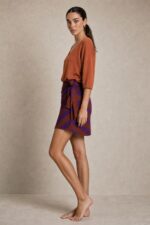 Bella Viscose Wrap Mini Skirt in rusty orange Κωδικός: 7891 Χαρακτηριστικά Προϊόντος • Mini κρουαζέ φούστα με ρυθμιζόμενο δέσιμο στη μέση • Διπλή εφαρμογή με εσωτερικό και εξωτερικό δέσιμο • Εσωτερικό φύλλο που ασφαλίζει με κορδονάκι • Εξωτερικό φύλλο που αγκαλιάζει το σώμα και δένει στη μέση • Προσαρμόζεται εύκολα στη σιλουέτα • Άνετη και θηλυκή γραμμή • One Size – καλύπτει έως Large • Ύφασμα από viscose blend σύνθεση • Ανάλαφρη, δροσερή και breathable αίσθηση • Μαλακή υφή με όμορφη φυσική κίνηση • Ιδανική για καθημερινές εμφανίσεις και καλοκαιρινά looks Διαστάσεις (One Size) • Μέση: έως 100 cm (ρυθμιζόμενη με δέσιμο) • Περιφέρεια: έως 110 cm • Μήκος: Mini Οδηγίες Φροντίδας • Πλύσιμο στους 30°C • Χωρίς στύψιμο • Σιδέρωμα σε χαμηλή θερμοκρασία