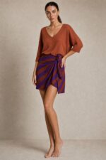 Bella Viscose Wrap Mini Skirt in rusty orange Κωδικός: 7891 Χαρακτηριστικά Προϊόντος • Mini κρουαζέ φούστα με ρυθμιζόμενο δέσιμο στη μέση • Διπλή εφαρμογή με εσωτερικό και εξωτερικό δέσιμο • Εσωτερικό φύλλο που ασφαλίζει με κορδονάκι • Εξωτερικό φύλλο που αγκαλιάζει το σώμα και δένει στη μέση • Προσαρμόζεται εύκολα στη σιλουέτα • Άνετη και θηλυκή γραμμή • One Size – καλύπτει έως Large • Ύφασμα από viscose blend σύνθεση • Ανάλαφρη, δροσερή και breathable αίσθηση • Μαλακή υφή με όμορφη φυσική κίνηση • Ιδανική για καθημερινές εμφανίσεις και καλοκαιρινά looks Διαστάσεις (One Size) • Μέση: έως 100 cm (ρυθμιζόμενη με δέσιμο) • Περιφέρεια: έως 110 cm • Μήκος: Mini Οδηγίες Φροντίδας • Πλύσιμο στους 30°C • Χωρίς στύψιμο • Σιδέρωμα σε χαμηλή θερμοκρασία