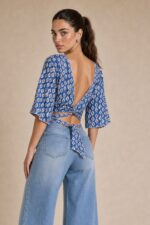 Iris Viscose Κρουαζέ Top in blue Χαρακτηριστικά Προϊόντος Πολυμορφικό κρουαζέ / wrap σχέδιο Δένει μπροστά ή πίσω Μπορεί να φορεθεί και ανάποδα Άνοιγμα μπροστά ή στην πλάτη, ανάλογα με το styling Άνετη γραμμή μανικιού ,μήκος κλασσικού κοντομάνικου Ασύμμετρο τελείωμα Άνετη, προσαρμοζόμενη εφαρμογή Πολύ μαλακό και δροσερό ύφασμα Ανάλαφρη & breathable αίσθηση Viscose Σημείωση για ευαίσθητα δέρματα: Η viscose έχει απαλή και λεία αίσθηση και μπορεί να αποτελεί άνετη επιλογή για άτομα που ενοχλούνται από πιο τραχιές υφές. Η ατομική ευαισθησία ή αλλεργία, ωστόσο, διαφέρει από άτομο σε άτομο. Διαστάσεις Μέγεθος Στήθος Μέση Μήκος One Size έως 100 cm Ρυθμιζόμενη με το δέσιμο Κανονικό crop Φροντίδα Πλύσιμο έως 30°C Χωρίς στύψιμο Σιδέρωμα σε κανονική θερμοκρασία