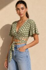 Iris Viscose Κρουαζέ Top in green Χαρακτηριστικά Προϊόντος Πολυμορφικό κρουαζέ / wrap σχέδιο Δένει μπροστά ή πίσω Μπορεί να φορεθεί και ανάποδα Άνοιγμα μπροστά ή στην πλάτη, ανάλογα με το styling Άνετη γραμμή μανικιού ,μήκος κλασσικού κοντομάνικου Ασύμμετρο τελείωμα Άνετη, προσαρμοζόμενη εφαρμογή Πολύ μαλακό και δροσερό ύφασμα Ανάλαφρη & breathable αίσθηση Viscose Σημείωση για ευαίσθητα δέρματα: Η viscose έχει απαλή και λεία αίσθηση και μπορεί να αποτελεί άνετη επιλογή για άτομα που ενοχλούνται από πιο τραχιές υφές. Η ατομική ευαισθησία ή αλλεργία, ωστόσο, διαφέρει από άτομο σε άτομο. Διαστάσεις Μέγεθος Στήθος Μέση Μήκος One Size έως 100 cm Ρυθμιζόμενη με το δέσιμο Κανονικό crop Φροντίδα Πλύσιμο έως 30°C Χωρίς στύψιμο Σιδέρωμα σε κανονική θερμοκρασία