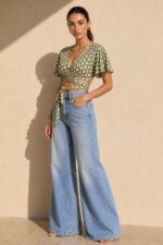 Iris Viscose Κρουαζέ Top in green Χαρακτηριστικά Προϊόντος Πολυμορφικό κρουαζέ / wrap σχέδιο Δένει μπροστά ή πίσω Μπορεί να φορεθεί και ανάποδα Άνοιγμα μπροστά ή στην πλάτη, ανάλογα με το styling Άνετη γραμμή μανικιού ,μήκος κλασσικού κοντομάνικου Ασύμμετρο τελείωμα Άνετη, προσαρμοζόμενη εφαρμογή Πολύ μαλακό και δροσερό ύφασμα Ανάλαφρη & breathable αίσθηση Viscose Σημείωση για ευαίσθητα δέρματα: Η viscose έχει απαλή και λεία αίσθηση και μπορεί να αποτελεί άνετη επιλογή για άτομα που ενοχλούνται από πιο τραχιές υφές. Η ατομική ευαισθησία ή αλλεργία, ωστόσο, διαφέρει από άτομο σε άτομο. Διαστάσεις Μέγεθος Στήθος Μέση Μήκος One Size έως 100 cm Ρυθμιζόμενη με το δέσιμο Κανονικό crop Φροντίδα Πλύσιμο έως 30°C Χωρίς στύψιμο Σιδέρωμα σε κανονική θερμοκρασία