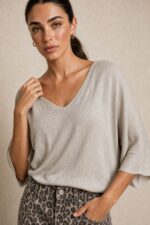 Katia Knitted Top in Beige Κωδ. 7030 Χαρακτηριστικά Προϊόντος • One Size – καλύπτει έως X-Large • Εξαιρετικά λεπτό πλεκτό μεταβατικής εποχής • Modal mix με πολύ απαλή υφή • Skin-friendly σύνθεση • V λαιμόκοψη • Φαρδιά μανίκια 3/4 • Χαλαρή, άνετη γραμμή • Ελαφριά και απαλή αίσθηση πάνω στο σώμα • Ιδανικό για άνοιξη, φθινόπωρο και layering • Nude απόχρωση που συνδυάζεται εύκολα Διαστάσεις ΜΕΓΕΘΟΣ ΣΤΗΘΟΣ ΠΕΡΙΦΕΡΕΙΑ ΜΗΚΟΣ One Size έως 120 cm έως 120 cm ~65 cm Οι διαστάσεις είναι ενδεικτικές λόγω της ελαστικότητας του πλεκτού. Σύνθεση • Modal Mix • Εξαιρετικά λεπτή πλεκτή ύφανση • Πολύ μαλακή & ελαφριά αίσθηση Φροντίδα • Πλύσιμο έως 30°C • Χωρίς έντονο στύψιμο • Στέγνωμα σε επίπεδη επιφάνεια ώστε να διατηρείται το σχήμα του πλεκτού • Όχι στεγνωτήριο