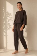 Set Viscose Loungewear in Brown Κωδ:18226 Χαρακτηριστικά Προϊόντος • Σετ μπλούζα & παντελόνι • One Size – καλύπτει έως X-Large • Ύφασμα: Πολύ μαλακή σύνθεση με viscose • Loose μπλούζα με φαρδύ μανίκι για άνετη εφαρμογή • Παντελόνι 7/8 μήκους, carrot fit • Ελαστική μέση για καλύτερη προσαρμογή • Πρακτικές πλαϊνές τσέπες • Απαλό, ελαφρύ και breathable ύφασμα • Κατάλληλο για καθημερινά, travel & loungewear looks • Non-iron ύφασμα Διαστάσεις (flat) • Στήθος μπλούζας: έως 120 cm • Μήκος μπλούζας: περίπου 68 cm • Μέση παντελονιού: 70–100 cm (ελαστική) • Περιφέρεια: έως 110 cm • Μήκος παντελονιού: περίπου 92 cm Φροντίδα • Πλύσιμο έως 30°C • Χωρίς στύψιμο