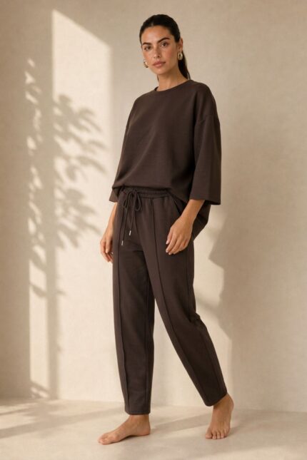 Set Viscose Loungewear in Brown Κωδ:18226 Χαρακτηριστικά Προϊόντος • Σετ μπλούζα & παντελόνι • One Size – καλύπτει έως X-Large • Ύφασμα: Πολύ μαλακή σύνθεση με viscose • Loose μπλούζα με φαρδύ μανίκι για άνετη εφαρμογή • Παντελόνι 7/8 μήκους, carrot fit • Ελαστική μέση για καλύτερη προσαρμογή • Πρακτικές πλαϊνές τσέπες • Απαλό, ελαφρύ και breathable ύφασμα • Κατάλληλο για καθημερινά, travel & loungewear looks • Non-iron ύφασμα Διαστάσεις (flat) • Στήθος μπλούζας: έως 120 cm • Μήκος μπλούζας: περίπου 68 cm • Μέση παντελονιού: 70–100 cm (ελαστική) • Περιφέρεια: έως 110 cm • Μήκος παντελονιού: περίπου 92 cm Φροντίδα • Πλύσιμο έως 30°C • Χωρίς στύψιμο