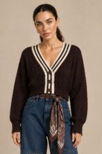 GNT Cable Knit Cardigan in Brown Χαρακτηριστικά Προϊόντος • Ύφασμα: Μαλακό πλεκτό • Ανάγλυφη cable knit / πλεξούδα ύφανση • V λαιμόκοψη • Contrast πλεκτή λεπτομέρεια περιμετρικά • Κλείσιμο μπροστά με κουμπιά • Μακριά μανίκια • Rib τελείωμα σε μανίκια και κάτω μέρος • Κανονική γραμμή • Κανονικό προς ελαφρώς cropped μήκος • Μαλακή και άνετη αίσθηση • One Size – καλύπτει έως Large Οδηγίες Φροντίδας • Πλύσιμο σε κρύο νερό • Στύψιμο μόνο σε χαμηλές στροφές • Στέγνωμα οριζόντια πάνω στην απλώστρα, ώστε να διατηρεί τη φόρμα του πλεκτού • Αποφύγετε το στεγνωτήριο και την άμεση επαφή με πηγές θερμότητας