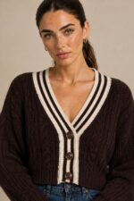 GNT Cable Knit Cardigan in Brown Χαρακτηριστικά Προϊόντος • Ύφασμα: Μαλακό πλεκτό • Ανάγλυφη cable knit / πλεξούδα ύφανση • V λαιμόκοψη • Contrast πλεκτή λεπτομέρεια περιμετρικά • Κλείσιμο μπροστά με κουμπιά • Μακριά μανίκια • Rib τελείωμα σε μανίκια και κάτω μέρος • Κανονική γραμμή • Κανονικό προς ελαφρώς cropped μήκος • Μαλακή και άνετη αίσθηση • One Size – καλύπτει έως Large Οδηγίες Φροντίδας • Πλύσιμο σε κρύο νερό • Στύψιμο μόνο σε χαμηλές στροφές • Στέγνωμα οριζόντια πάνω στην απλώστρα, ώστε να διατηρεί τη φόρμα του πλεκτού • Αποφύγετε το στεγνωτήριο και την άμεση επαφή με πηγές θερμότητας