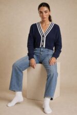 GNT Cable Knit Cardigan in Burgundy Χαρακτηριστικά Προϊόντος • Ύφασμα: Μαλακό πλεκτό • Ανάγλυφη cable knit / πλεξούδα ύφανση • V λαιμόκοψη • Contrast πλεκτή λεπτομέρεια περιμετρικά • Κλείσιμο μπροστά με κουμπιά • Μακριά μανίκια • Rib τελείωμα σε μανίκια και κάτω μέρος • Κανονική γραμμή • Κανονικό προς ελαφρώς cropped μήκος • Μαλακή και άνετη αίσθηση • One Size – καλύπτει έως Large Οδηγίες Φροντίδας • Πλύσιμο σε κρύο νερό • Στύψιμο μόνο σε χαμηλές στροφές • Στέγνωμα οριζόντια πάνω στην απλώστρα, ώστε να διατηρεί τη φόρμα του πλεκτού • Αποφύγετε το στεγνωτήριο και την άμεση επαφή με πηγές θερμότητας