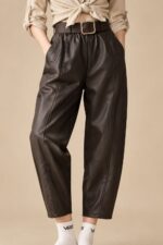 Παντελόνι Δερματίνη in Brown Κωδ:1610126 Χαρακτηριστικά Προϊόντος Ύφασμα: Μαλακή, λεία δερματίνη (leather effect) Φινίρισμα: Matte  Γραμμή: Άνετη, κανονική προς φαρδιά Barrel-inspired σχεδιασμός με χαλαρή σιλουέτα Κανονικό μήκος Άνετο μπατζάκι με ελαφρώς στρογγυλεμένη γραμμή Λάστιχο στο πίσω μέρος της μέσης για μεγαλύτερη άνεση Πρακτικές πλαϊνές τσέπες Κάθετες διακοσμητικές ραφές Μαλακή υφή και άνετη αίσθηση Οδηγίες Φροντίδας Πλύσιμο στους 30°C ή σε κρύο νερό, σε πρόγραμμα για ευαίσθητα. Χωρίς στύψιμο, για την προστασία της δερματίνης. Όχι στεγνωτήριο. Φυσικό στέγνωμα στη σκιά, μακριά από άμεση ηλιακή ακτινοβολία. Όχι σιδέρωμα. Μακριά από καλοριφέρ και άμεσες πηγές θερμότητας.
