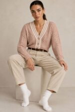 GNT Cable Knit Cardigan in Dusty Pink Χαρακτηριστικά Προϊόντος • Ύφασμα: Μαλακό πλεκτό • Ανάγλυφη cable knit / πλεξούδα ύφανση • V λαιμόκοψη • Contrast πλεκτή λεπτομέρεια περιμετρικά • Κλείσιμο μπροστά με κουμπιά • Μακριά μανίκια • Rib τελείωμα σε μανίκια και κάτω μέρος • Κανονική γραμμή • Κανονικό προς ελαφρώς cropped μήκος • Μαλακή και άνετη αίσθηση • One Size – καλύπτει έως Large Οδηγίες Φροντίδας • Πλύσιμο σε κρύο νερό • Στύψιμο μόνο σε χαμηλές στροφές • Στέγνωμα οριζόντια πάνω στην απλώστρα, ώστε να διατηρεί τη φόρμα του πλεκτού • Αποφύγετε το στεγνωτήριο και την άμεση επαφή με πηγές θερμότητας
