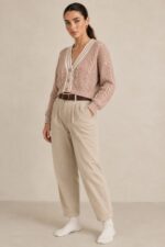 GNT Cable Knit Cardigan in Dusty Pink Χαρακτηριστικά Προϊόντος • Ύφασμα: Μαλακό πλεκτό • Ανάγλυφη cable knit / πλεξούδα ύφανση • V λαιμόκοψη • Contrast πλεκτή λεπτομέρεια περιμετρικά • Κλείσιμο μπροστά με κουμπιά • Μακριά μανίκια • Rib τελείωμα σε μανίκια και κάτω μέρος • Κανονική γραμμή • Κανονικό προς ελαφρώς cropped μήκος • Μαλακή και άνετη αίσθηση • One Size – καλύπτει έως Large Οδηγίες Φροντίδας • Πλύσιμο σε κρύο νερό • Στύψιμο μόνο σε χαμηλές στροφές • Στέγνωμα οριζόντια πάνω στην απλώστρα, ώστε να διατηρεί τη φόρμα του πλεκτού • Αποφύγετε το στεγνωτήριο και την άμεση επαφή με πηγές θερμότητας