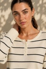 Striped Sugar Sweater – Ριγέ Πλεκτή Μπλούζα με Κουμπιά Κωδ:211026 Χαρακτηριστικά Προϊόντος Σύνθεση: Viscose – Modal Mix Ύφασμα: Λεπτό, εξαιρετικά απαλό πλεκτό Υφή: Λεία, φίνα και ιδιαίτερα ευχάριστη στην επαφή με το σώμα Γραμμή: Ελαφρώς oversized – relaxed fit Μέγεθος: One Size καλύπτει έως large Στρογγυλή λαιμόκοψη Μπροστινή πατιλέτα με μικρά κουμπιά Ribbed μανσέτες και τελείωμα Λεπτές οριζόντιες ρίγες Ανάλαφρη πλέξη χωρίς περιττό όγκο Ιδανικό για layering και καθημερινές εμφανίσεις Οδηγίες Φροντίδας 30°C – Πλύσιμο σε κρύο νερό, σε πρόγραμμα για ευαίσθητα. Χωρίς στύψιμο, για την προστασία της λεπτής πλέξης.  Όχι στεγνωτήριο.  Στέγνωμα οριζόντια, πάνω σε καθαρή απλώστρα, ώστε να διατηρείται η φόρμα του πλεκτού. Αποφύγετε το κρέμασμα όσο το πλεκτό είναι βρεγμένο. Συνιστάται αποφυγή υψηλών θερμοκρασιών και άμεσης έκθεσης στον ήλιο.