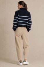 Julia Knitted Jumper in navy – Ριγέ Πλεκτό Πουλόβερ με Φερμουάρ Χαρακτηριστικά Προϊόντος Σύνθεση: Wool – Alpaca blend Ύφασμα: Εξαιρετικά μαλακό, χνουδωτό πλεκτό Γραμμή: Oversized – άνετη και χαλαρή Μέγεθος: One Size – καλύπτει έως L Plus Μήκος: Κανονικό Κλείσιμο με κοντό φερμουάρ μπροστά (half zip) Ribbed τελείωμα στις μανσέτες και στη βάση Διακριτικό οριζόντιο ριγέ σχέδιο Ανάλαφρη, ζεστή και απαλή πλέξη Ευχάριστη αίσθηση στην επαφή με το δέρμα Εφαρμογή & Μέγεθος One Size – καλύπτει έως XL Plus. Η oversized γραμμή προσφέρει άνεση και ελευθερία κινήσεων, χωρίς να περιορίζει τη σιλουέτα. Η τελική εφαρμογή εξαρτάται από τον σωματότυπο και τον βαθμό χαλαρότητας που επιθυμείτε. Οδηγίες Φροντίδας  Πλύσιμο σε κρύο νερό, σε πρόγραμμα για ευαίσθητα ή μάλλινα. Χωρίς στύψιμο, για την προστασία της πλέξης.  Όχι στεγνωτήριο. Στέγνωμα οριζόντια, πάνω σε καθαρή απλώστρα, ώστε να διατηρείται η φόρμα του πλεκτού. Όχι σιδέρωμα. Αποφύγετε την άμεση έκθεση στον ήλιο και σε πηγές θερμότητας, όπως καλοριφέρ. Για μεγαλύτερη διάρκεια ζωής, συνιστάται η χρήση ειδικού απορρυπαντικού για μάλλινα και το στέγνωμα χωρίς κρέμασμα.