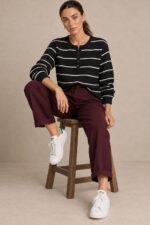 Striped Sugar Sweater in black – Ριγέ Πλεκτή Μπλούζα με Κουμπιά Κωδ:211026 Χαρακτηριστικά Προϊόντος Σύνθεση: Viscose – Modal Mix Ύφασμα: Λεπτό, εξαιρετικά απαλό πλεκτό viscose - modal blend Υφή: Λεία, φίνα και ιδιαίτερα ευχάριστη στην επαφή με το σώμα Γραμμή: Ελαφρώς oversized – relaxed fit Μέγεθος: One Size καλύπτει έως large Στρογγυλή λαιμόκοψη Μπροστινή πατιλέτα με μικρά κουμπιά Ribbed μανσέτες και τελείωμα Λεπτές οριζόντιες ρίγες Ανάλαφρη πλέξη χωρίς περιττό όγκο Ιδανικό για layering και καθημερινές εμφανίσεις Οδηγίες Φροντίδας 30°C – Πλύσιμο σε κρύο νερό, σε πρόγραμμα για ευαίσθητα. Χωρίς στύψιμο, για την προστασία της λεπτής πλέξης.  Όχι στεγνωτήριο.  Στέγνωμα οριζόντια, πάνω σε καθαρή απλώστρα, ώστε να διατηρείται η φόρμα του πλεκτού. Αποφύγετε το κρέμασμα όσο το πλεκτό είναι βρεγμένο. Συνιστάται αποφυγή υψηλών θερμοκρασιών και άμεσης έκθεσης στον ήλιο.