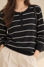 Striped Sugar Sweater in black – Ριγέ Πλεκτή Μπλούζα με Κουμπιά Κωδ:211026 Χαρακτηριστικά Προϊόντος Σύνθεση: Viscose – Modal Mix Ύφασμα: Λεπτό, εξαιρετικά απαλό πλεκτό viscose - modal blend Υφή: Λεία, φίνα και ιδιαίτερα ευχάριστη στην επαφή με το σώμα Γραμμή: Ελαφρώς oversized – relaxed fit Μέγεθος: One Size καλύπτει έως large Στρογγυλή λαιμόκοψη Μπροστινή πατιλέτα με μικρά κουμπιά Ribbed μανσέτες και τελείωμα Λεπτές οριζόντιες ρίγες Ανάλαφρη πλέξη χωρίς περιττό όγκο Ιδανικό για layering και καθημερινές εμφανίσεις Οδηγίες Φροντίδας 30°C – Πλύσιμο σε κρύο νερό, σε πρόγραμμα για ευαίσθητα. Χωρίς στύψιμο, για την προστασία της λεπτής πλέξης.  Όχι στεγνωτήριο.  Στέγνωμα οριζόντια, πάνω σε καθαρή απλώστρα, ώστε να διατηρείται η φόρμα του πλεκτού. Αποφύγετε το κρέμασμα όσο το πλεκτό είναι βρεγμένο. Συνιστάται αποφυγή υψηλών θερμοκρασιών και άμεσης έκθεσης στον ήλιο.